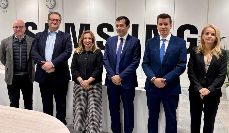 Seis profesionales trajeados posan juntos en una sala de reuniones ante el logotipo de Samsung en la pared